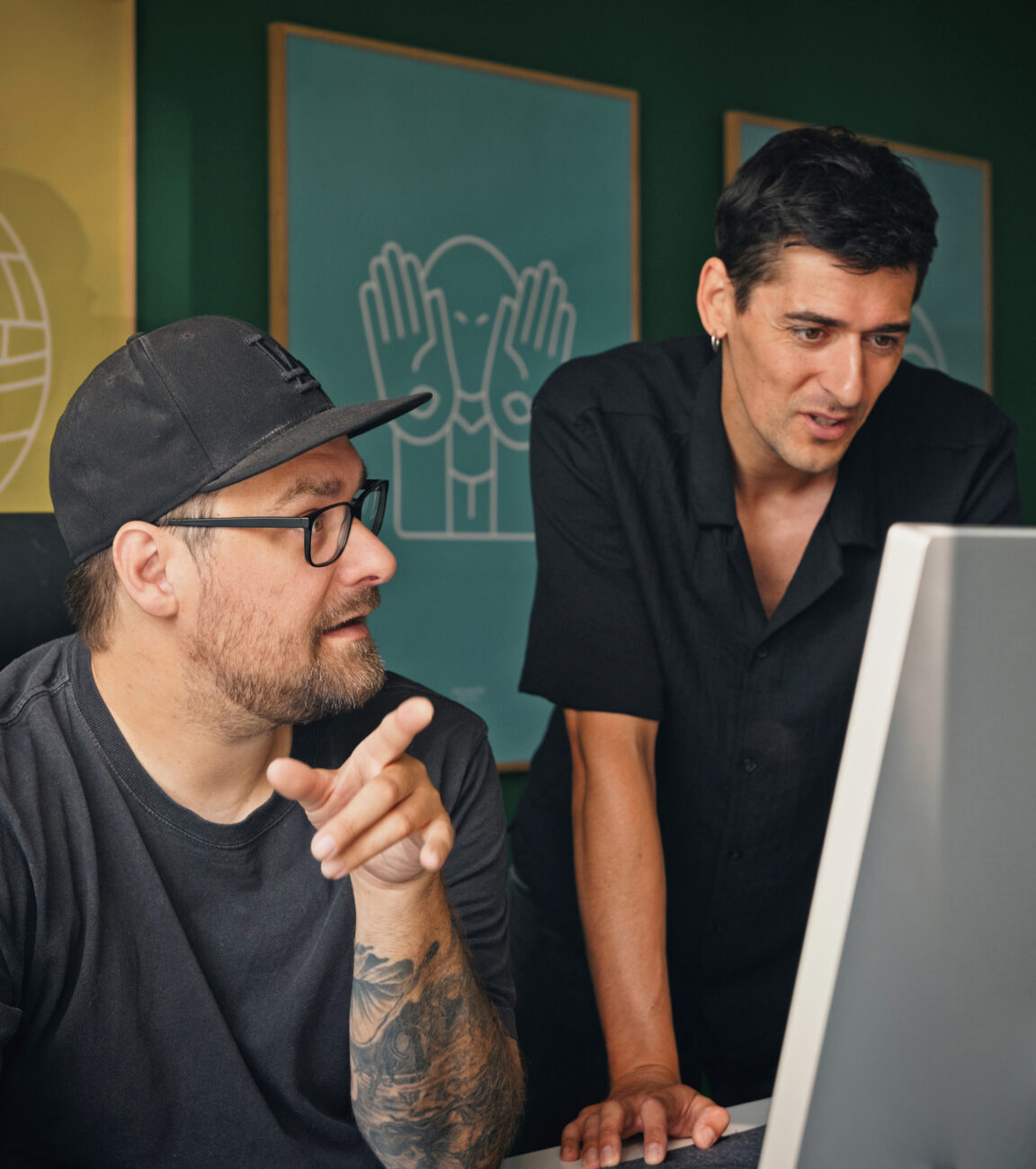 Zwei Kollegen von seitenweise besprechen ein Projekt am Bildschirm