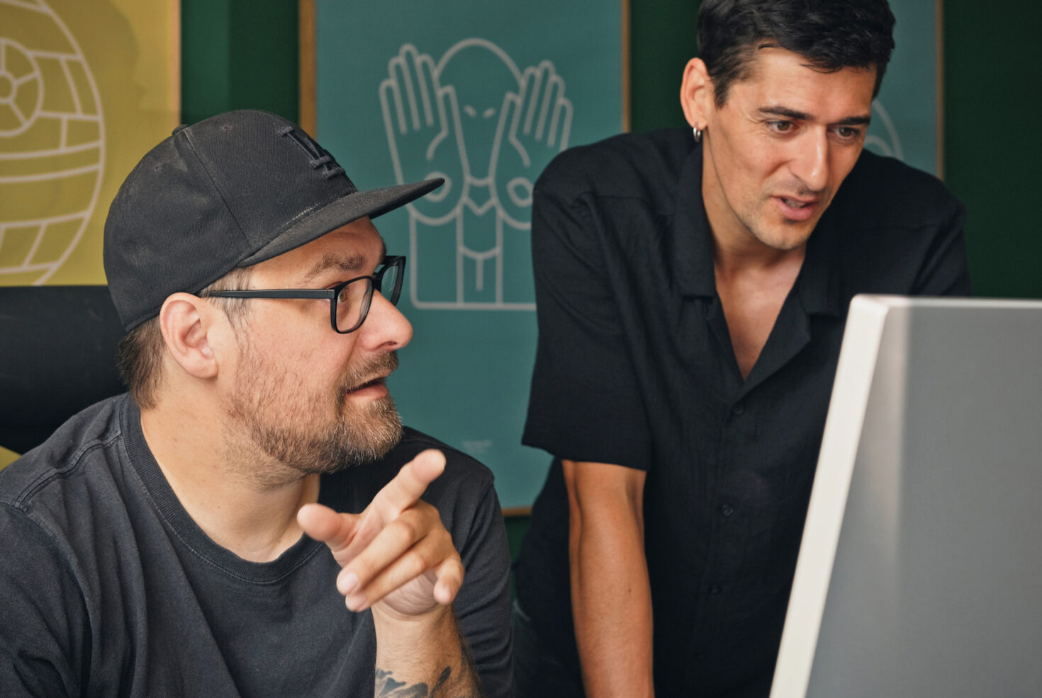 Zwei Kollegen von seitenweise besprechen ein Projekt am Bildschirm
