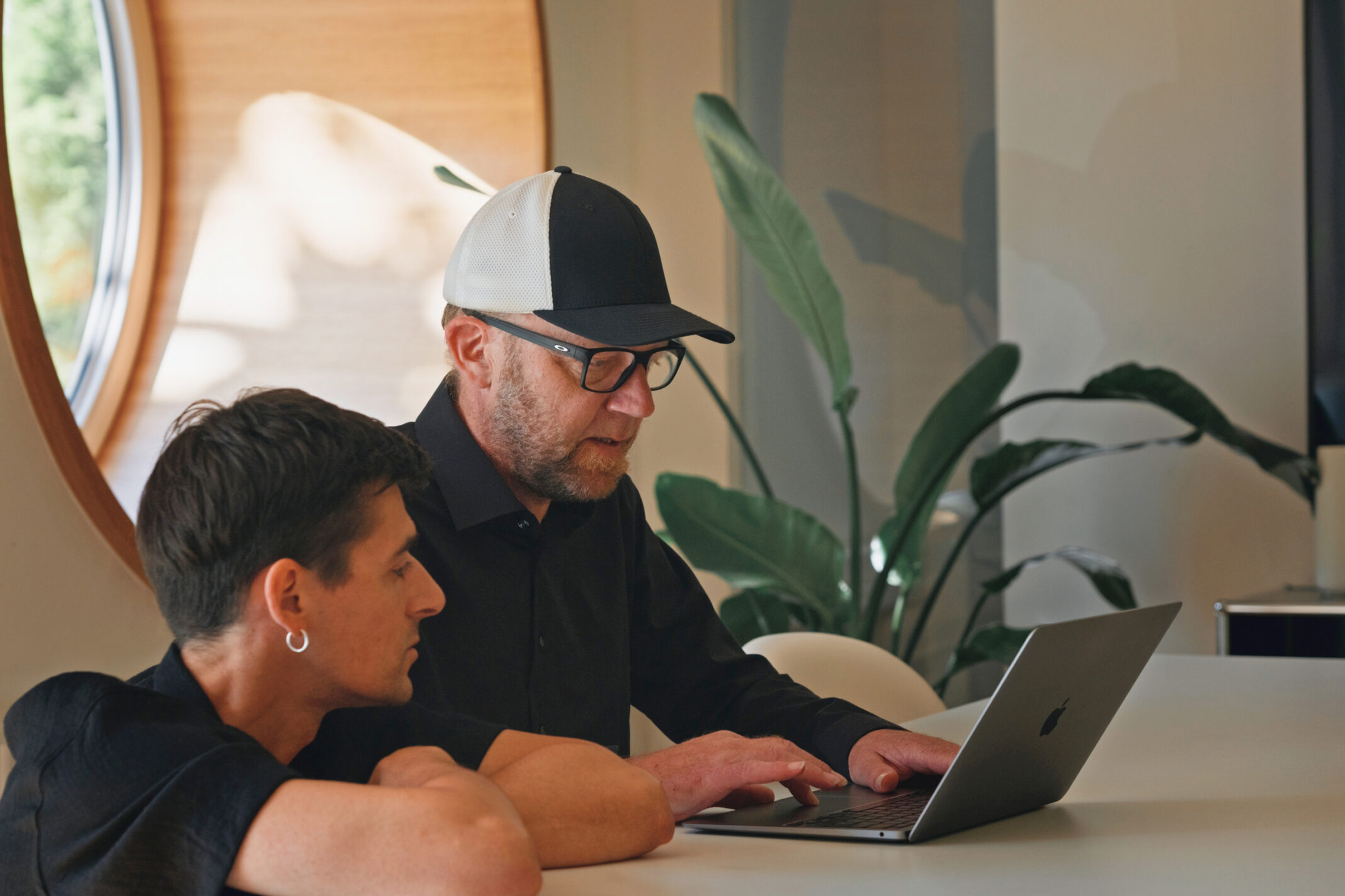 Zwei Kollegen von seitenweise arbeiten gemeinsam am Laptop