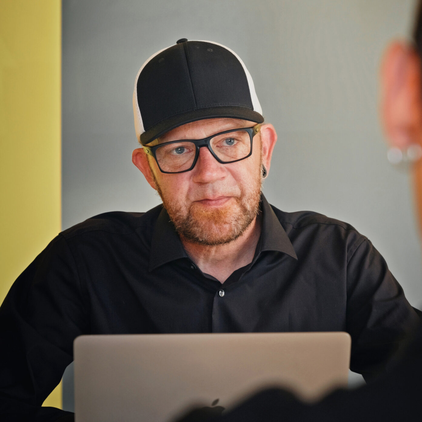 Mitarbeiter von seitenweise arbeitet in einer Besprechung am Laptop