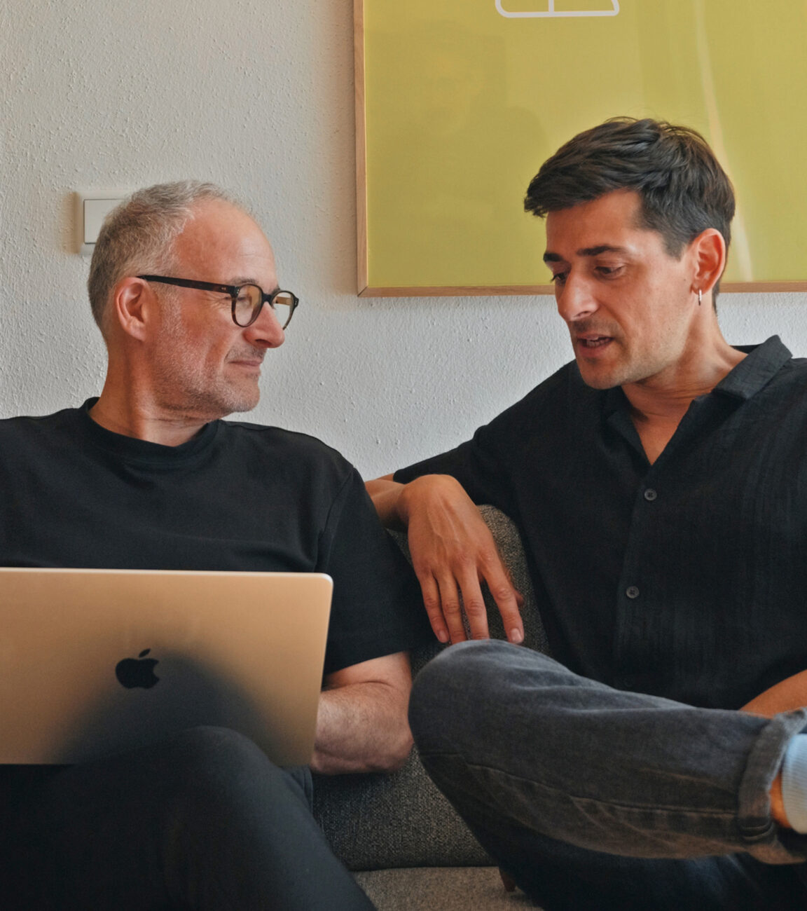 Zwei Kollegen von seitenweise arbeiten gemeinsam am Laptop