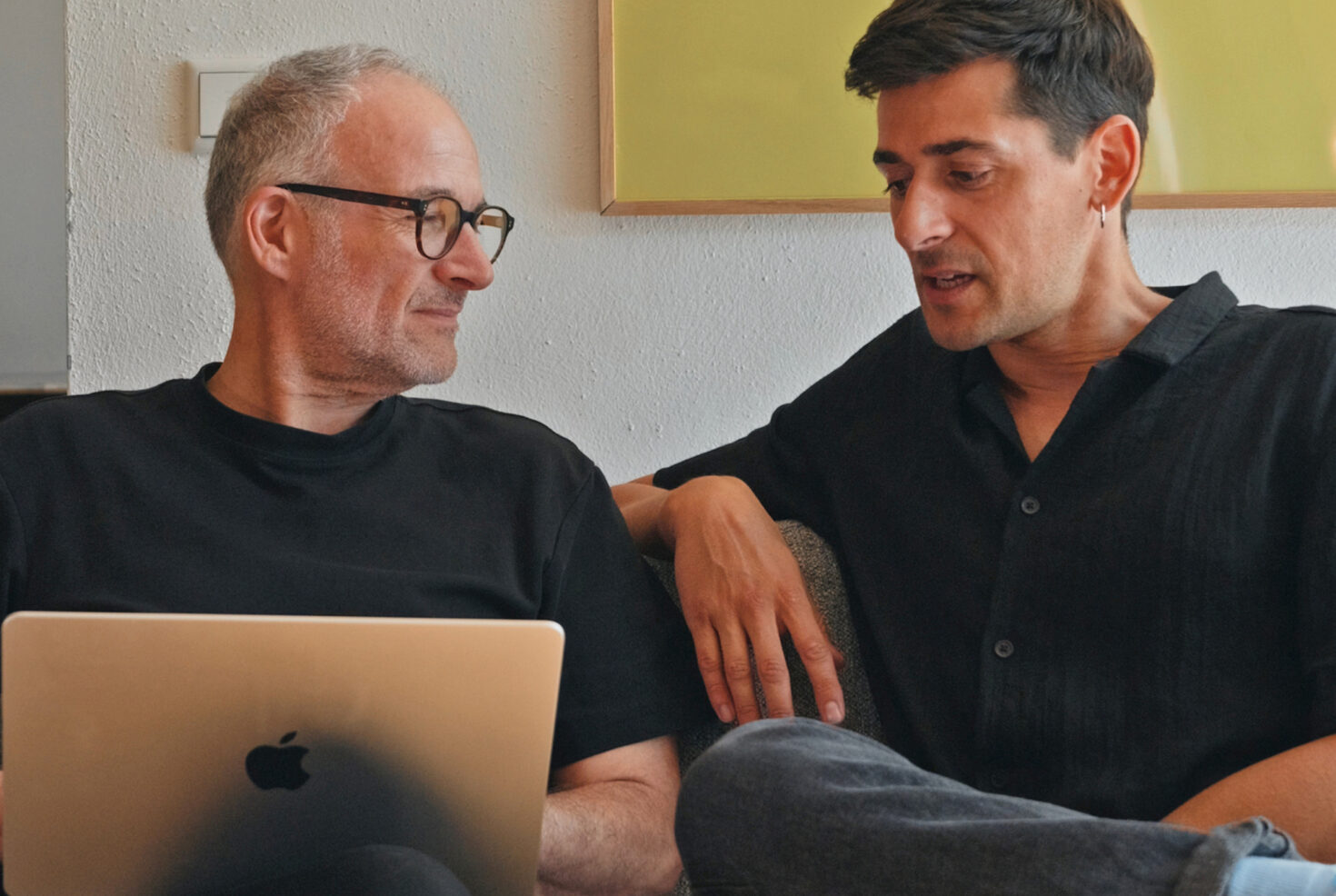 Zwei Kollegen von seitenweise arbeiten gemeinsam am Laptop
