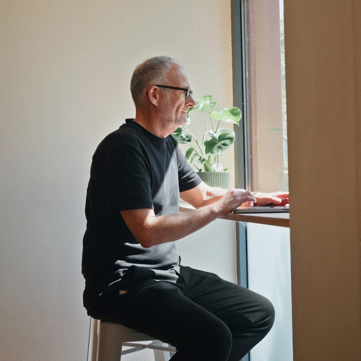 Mitarbeiter von seitenweise arbeitet am Laptop am Fenster