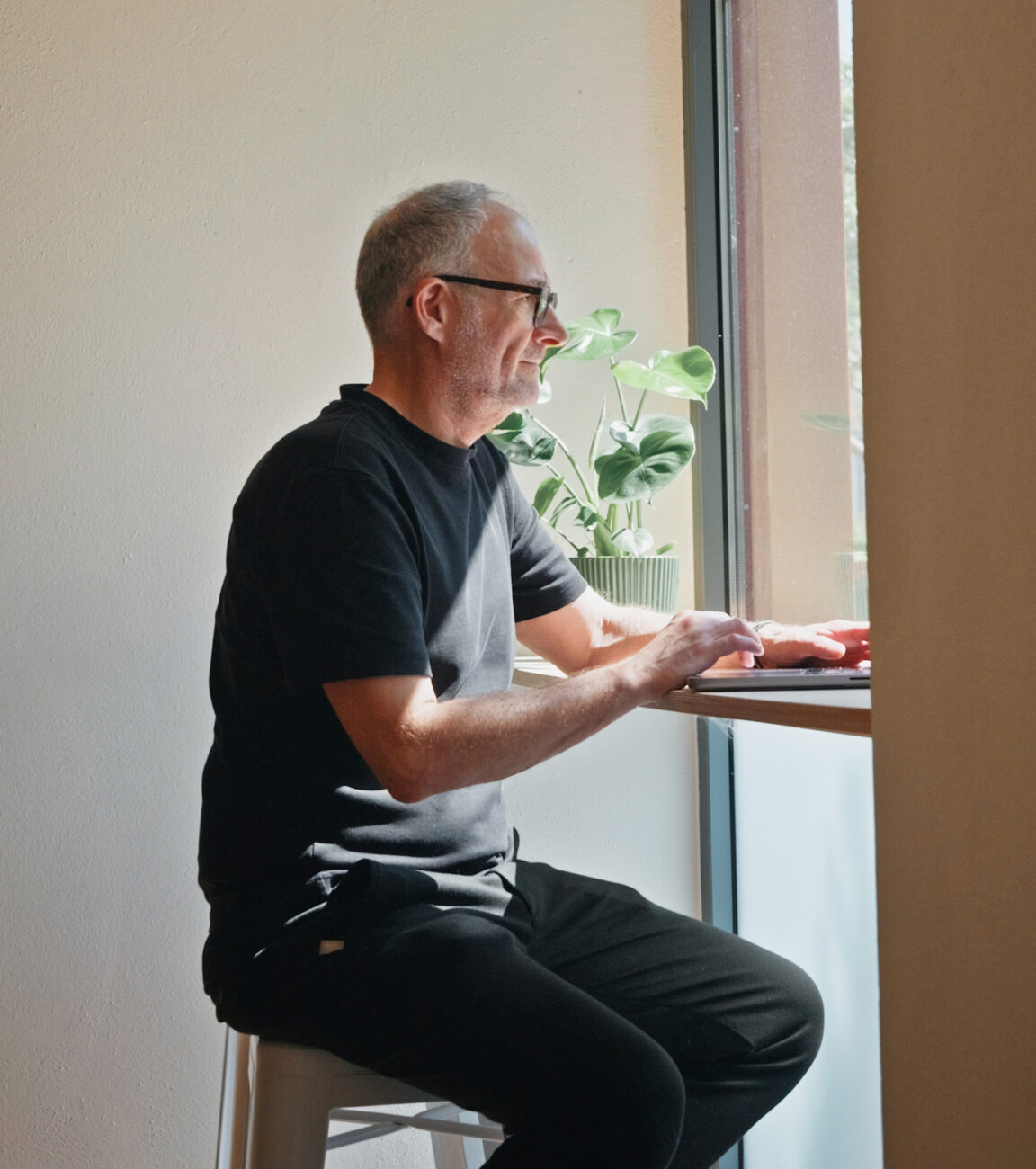 Mitarbeiter von seitenweise arbeitet am Laptop am Fenster